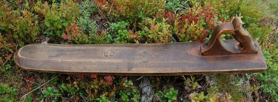 board with ornate curly handle on top, little other carving